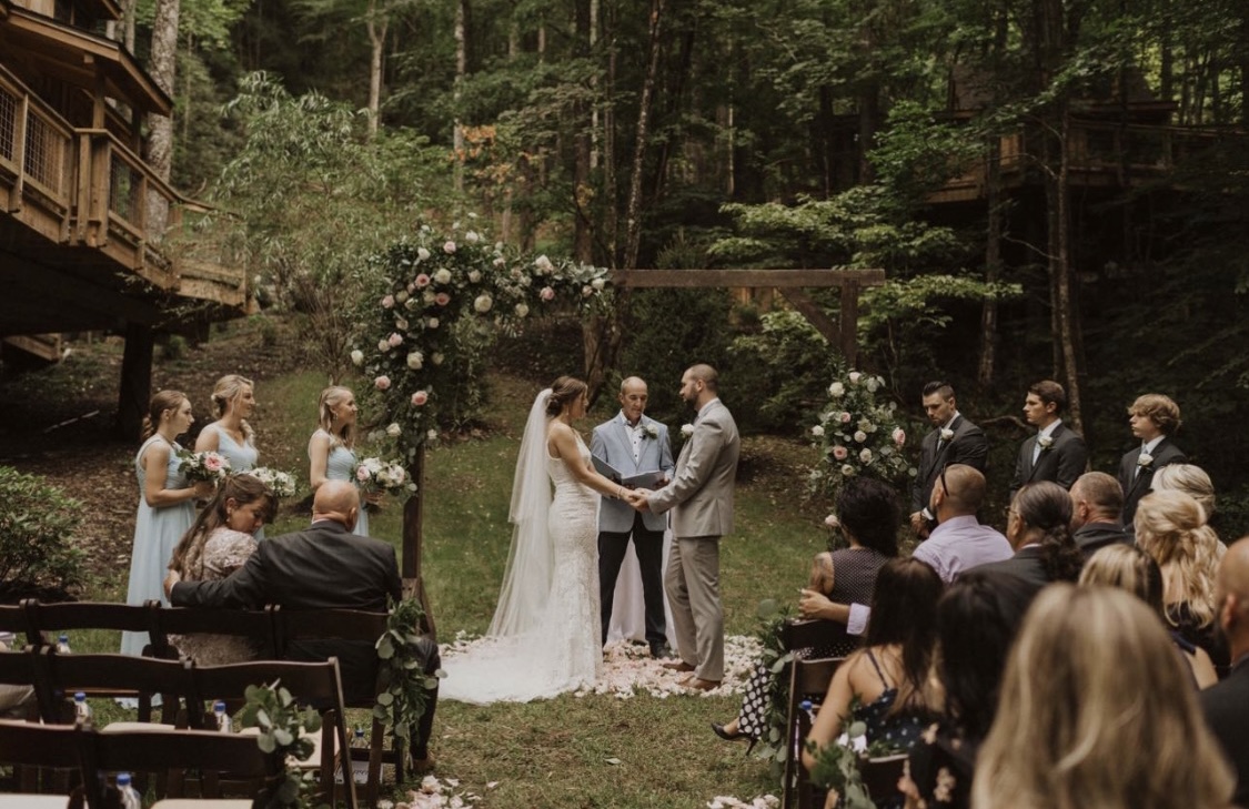 Wedding ceremony at Treehouse Grove with bridesmaids, groomsmen, and seated guests