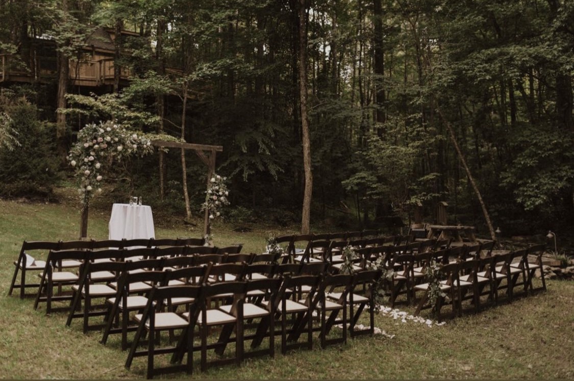 Empty ceremony space set up among the trees, reserved just for one couple